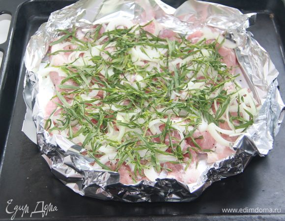 На мясо выложить репчатый лук, нарезанный полукольцами, тархун (без веточек, только листики).