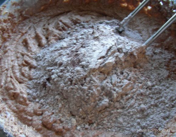 Затем начинаем добавлять сухую смесь небольшими порциями к масляно-сахарной смеси, чередуя с жидкой смесью из кока-колы. Начинаем и заканчиваем сухой смесью. Сильно взбивать не надо - просто на низкой скорости миксера до получения однородной массы. 
