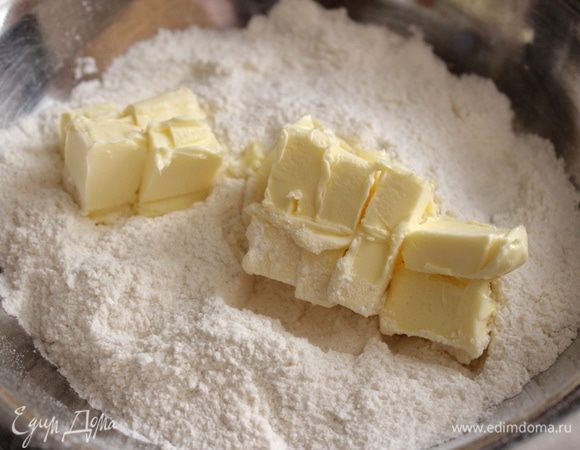 Муку смешать с сахаром, солью, разрыхлителем и ванилином. Размягчённое масло нарезать кубиками и растереть с мучной смесью в крошку.