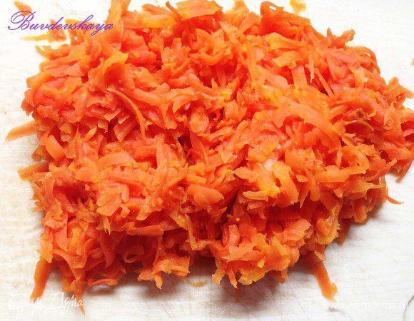 Морковь натереть на крупной терке и выложить на лук. Смазать майонезом, разровнять силиконовой лопаткой, украсить веточками зелени и половинками грецких орехов.