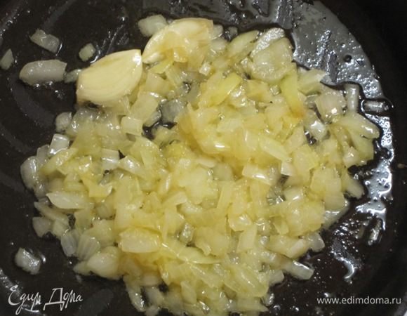 Креветки со сковороды выложить в тарелку. В этой же сковороде обжарить мелко нарезанный лук и раздавленный зубчик чеснока.