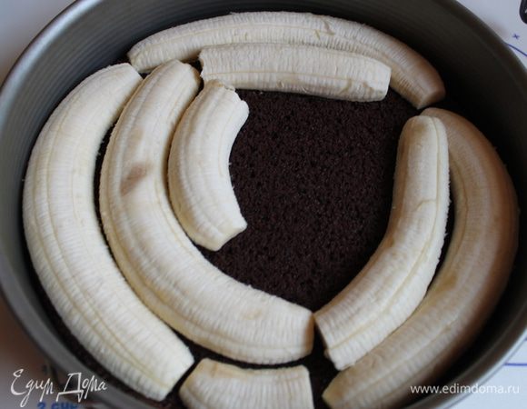 Берем бананы, чистим и режем вдоль. Укладываем их на торт. У меня ушло 4 банана.