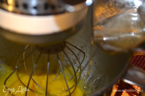 Начать взбивать желтки на высокой скорости миксера и постепенно, тоненькой струйкой влить горячий сахарный сироп.