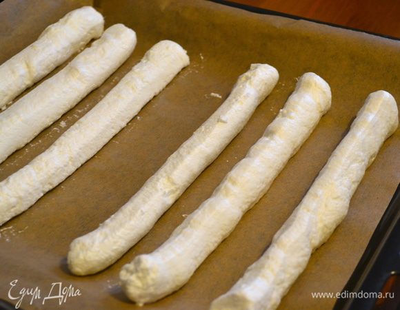 Наполнить кондитерский мешок с ровной и круглой насадкой, диаметром 2 см, и отсадите на подготовленный противень три длинные полоски, на расстоянии 1,5 см друг от друга. Затем пропустить 3 см и отсадить еще 3 такие же полоски.
