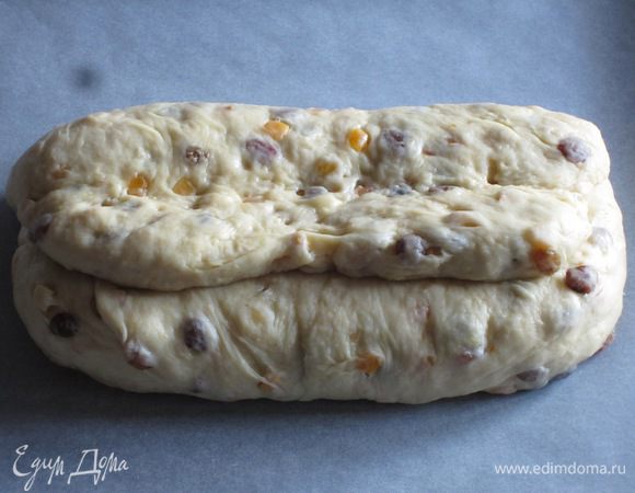 Выложить штоллен на противень с пергаментом и выпекать в разогретой до 180 °С духовке 40 -50 минут до золотистого цвета. 
