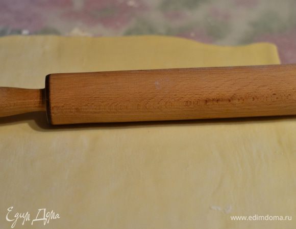 Готовое слоеное тесто на присыпанной мукой рабочей поверхности раскатываем в прямоугольник .