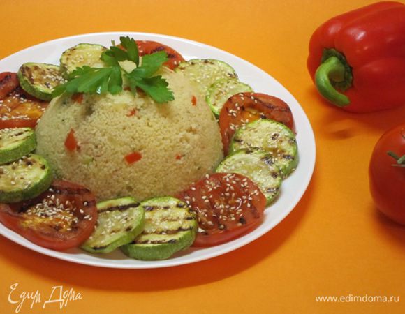 Выложить кускус в центр тарелки. Вокруг выложить обжаренные на гриле кабачок и помидор. Посолить, поперчить, посыпать кунжутом.