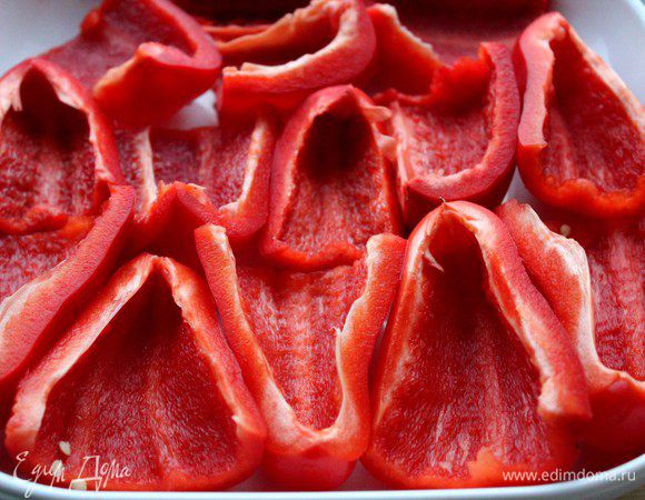 Перцы помыть, разрезать на сегменты, удалить семечки, сбрызгнуть оливковым маслом и запечь в духовке до мягкости (15-20 минут). Переложить в пакет и оставить на 10 мин. Очистить перцы от кожицы.