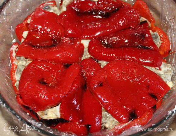 Слегка утрамбовать салат, накрыть оставшимся перцем. Завернуть края пленки к центру, накрыть тарелкой и поставить од гнет.  Убрать террин в холодильник на ночь. На следующий день развернуть концы пленки, слить выделившийся сок. Перевернуть террин на блюдо, снять пленку.