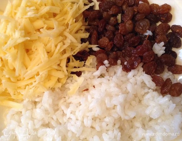 Подготовить начинку - сварить рис до полуготовности, потереть сыр на крупной терке, промыть изюм (не замачивать).