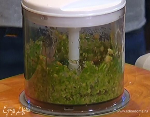 Приготовить соус песто: в чаше блендера соединить грецкие орехи, руколу, чеснок, влить оливковое масло, посолить и взбить все в однородную массу.