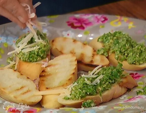 Намазать кростини соусом песто, посыпать оставшимся сыром.