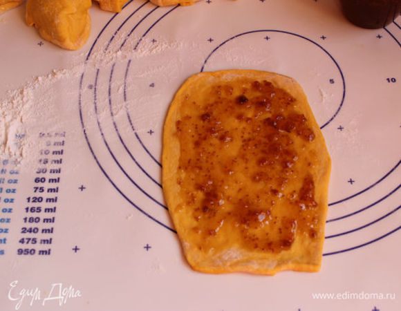 Раскатаем одну лепешку тонко , надо чтобы она была прямоугольной формы. Намажем джемом любым. У меня был апельсиновый с инжиром. Я делала несколько с вареньем и несколько с готовой маковой начинкой. 