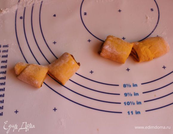 Скатаем рулетик и разрежем его пополам. Теперь мы эти половинки надрезаем еще по середине не до конца.