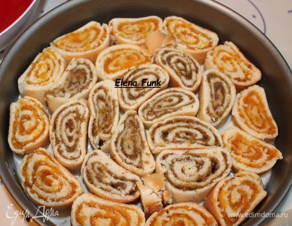 Делаем крем. Разводим сметану с сахаром. Хорошо размешаем, сахар должен раствориться.Теперь берем форму,26см,  застилаем дно бумагой. 
На дно выливаем 3 ложки сметанного крема. И выкладываем плотно наши рулетики. Вот таким образом . Сначала у меня были с курагой и изюмом.  Зальем их сверху еще кремом.