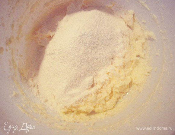 Просеянную муку смешать с разрыхлителем и постепенно всыпать в масло. Замесить мягкое тесто.