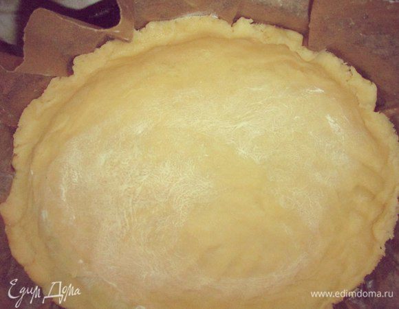 В форму с бумагой выложить тесто, сделать бортики.