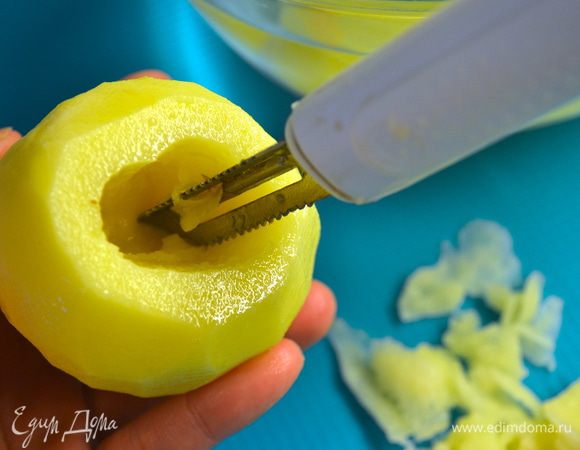 Первым делом подготовить картофель. Клубни лучше всего выбрать одинакового размера, достаточно крупные. Сорт картофеля должен быть из тех, что не разваливаются при варке или тушении, это так называемый картофель с желтой мякотью. Очистить картофелину и слегка срезать основание, чтобы картофелина "стояла"... ))) Затем также срезать немного верхушку, а затем начать осторожно извлечь мякоть из клубня. Мне в этом деле очень помог ножичек-овощечистка. Очень удобно... 