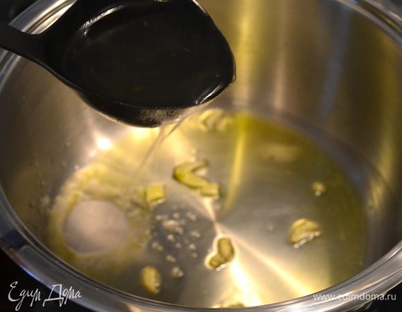 Заранее подготовить овощной бульон. Он должен быть горячим. В большой кастрюле с толстым дном будем готовить мясное рагу по-итальянски... Налить в кастрюлю немного оливкового масла, 2-3 ст.л. Поставить на огонь. Положить обжариваться нарезанный тонкими пластинками зубчик чеснока.  Как только чеснок начнет шипеть, добавить пол половника бульона, чтобы чеснок не горел! 