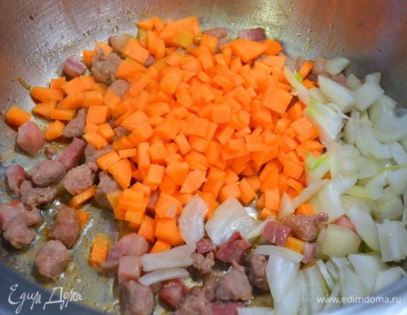 Морковь и лук нарезать небольшими кубиками и добавить в кастрюлю. Перемешать и дать обжариться еще 5 минут.
