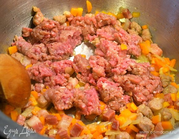 Добавить говяжий фарш. Перемешать, размять фарш ложкой.