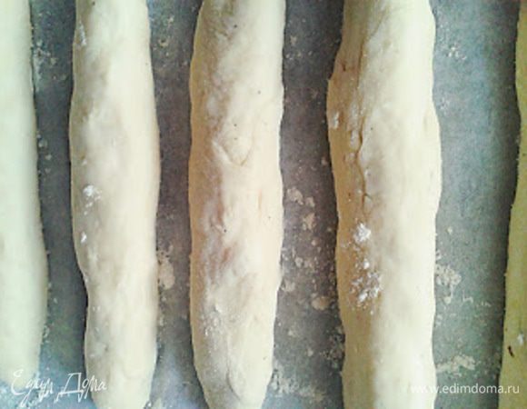 Тесто разделить на 20 одинаковых частей, раскатать "колбаски", длиной примерно 10-15 см   Противень застелить бумагой для выпечки и выложить "колбаски", не вплотную друг к другу, а оставляя расстояние между ними.  Дать постоять тесту 5 минут и потом положить в духовку.
