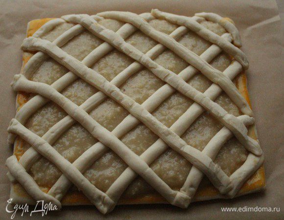 Края теста смазать желтком и выложить полоски теста в виде решетки.