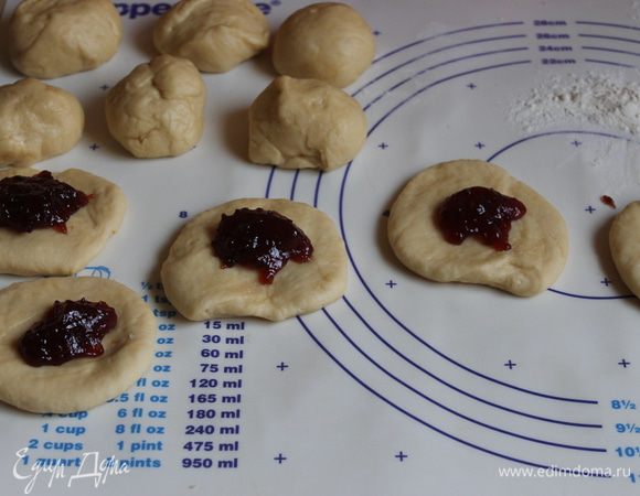 Раскатаем лепешку слегка. Я взяла на этот раз повидло сливовое, домашнее. Можно взять любую начинку. Кладем на серединку примерно чайную ложку.