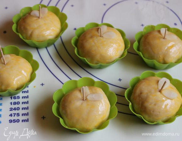 Смажем желтком смешанным с молоком. Берем зубочистку, режем пополам и втыкаем в серединку. Еще можно сделать листики из миндаля.Ставим на полчаса для расстойки. Нагреваем духовку до 180 градусов. И выпекаем наши яблочки 20 минут до золотистого цвета. 