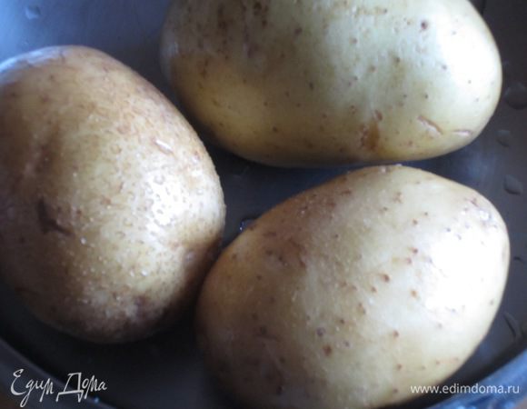 Картофель помыть, завернуть в пищевую фольгу, положить на противень и запекать в разогретой до 200 °С духовке 30 минут.