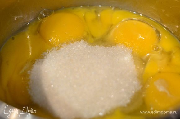 Яичные желтки и 2 целых яйца засыпать сахаром и отправить на плиту, включить средний огонь и варить, постоянно помешивая венчиком до небольшого загустения.