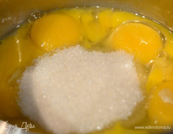 Яичные желтки и 2 целых яйца засыпать сахаром и отправить на плиту, включить средний огонь и варить, постоянно помешивая венчиком до небольшого загустения.