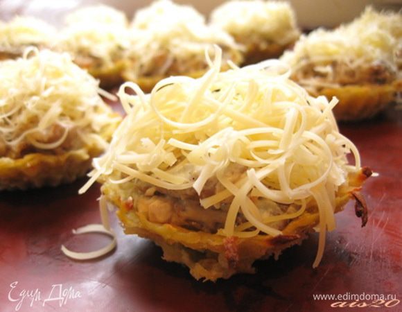 Готовой начинкой наполнить кокотницы. Сверху посыпать тертым сыром.