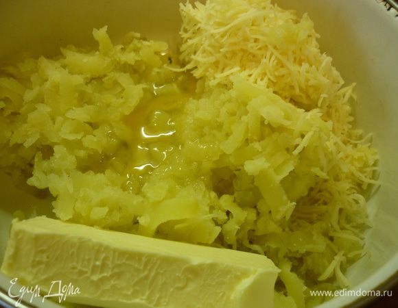 Вареную картошку натираем на терке.Но вполне можно и толкушкой ее помять. Добавим натертый сыр (немножко оставить на посыпку сверху), белок, соль, размягченное масло. Все перемешиваем, добавляем порциями муку. Получается липкое тесто. В холодильник его. Чтоб застыло. Так меньше будет липнуть и легче раскатывать.