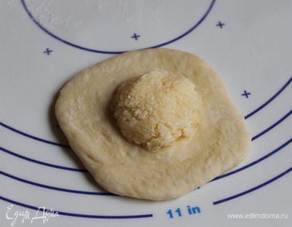 Раскатаем слегка наши кружки и на середину кладем шарик из начинки.