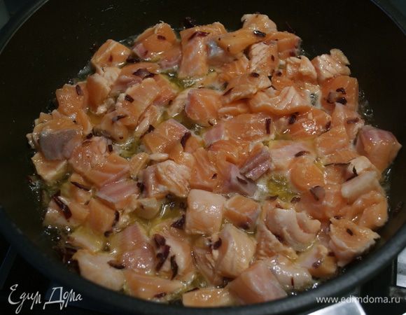 Между тем нарезать филе свежей семги (предварительно очистив от кожуры и удалив косточки) на полоски, а затем на небольшие квадратики. Добавить кусочки рыбы к луку... Как только кусочки рыбы слегка поджарятся (посветлеют), влить рюмку бренди и дать выпариться алкоголю. 