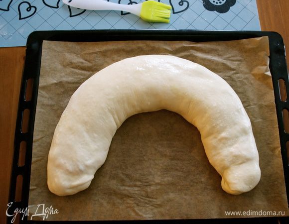 Перенести осторожно на противень, застеленный пекарской бумагой, и придать форму подковы. Смазать поверхность штруделя оставшимся белком. И присыпать смесью кунжутного семени и мака. 