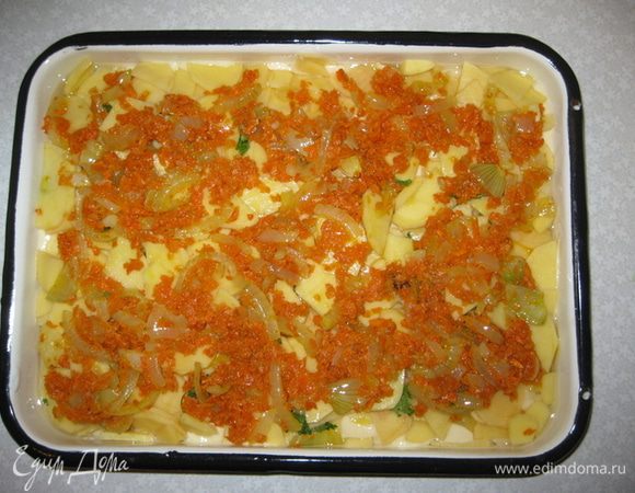 Форму смазываем растительным масло.  Выкладываем 1/3 часть теста, на него выкладываем тонко порезанный сырой картофель картофель и петрушку, сверху лук и морковь. Солим по вкусу. 