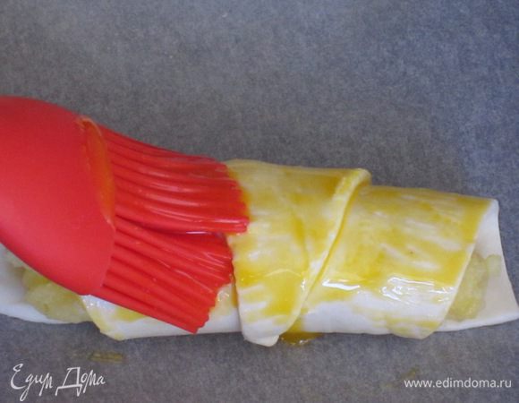 И скатать в рогалик (от широкой части к узкой). Cмазать поверхность взбитым желтком...