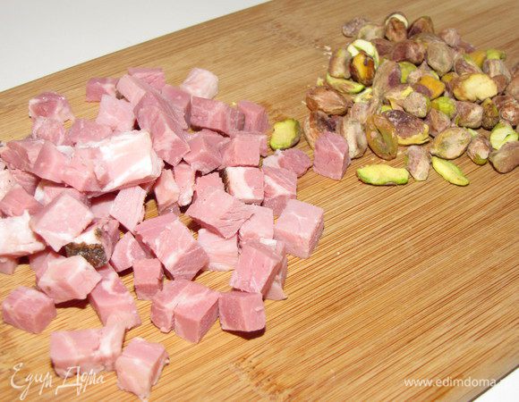 Ветчину нарезать кубиком, фисташки почистить.