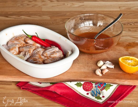 После маринования, смахнуть с цыпленка остатки маринада. Уложить на противень застеленный пергаментом. Вместе с перцем и разрезанным пополам чесноком.