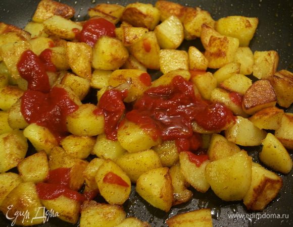 Снова увеличить огонь и добавить в сковороду разведенный томатный концентрат. Перемешивая подержать на огне еще 3 минуты, позволяя соусу распределиться по картошке. 