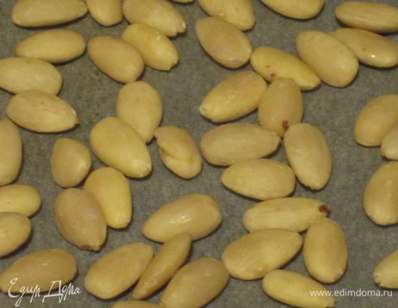 Миндаль и фундук выложить на противень с пергаментом и поставить в разогретую до 200 °С духовку на 5 минут. Шоколад измельчить.