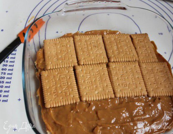 Сверху выкладываем банку вареной сгущенки. Разравниваем ее аккуратно. И  кладем еще слой печенья.