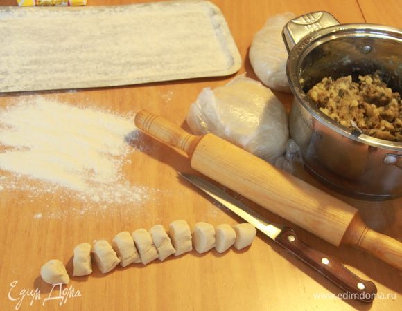 Тесто и начинка готовы, можно приступать к лепке вареников. Отрезаем от общего куска теста небольшую часть и раскатываем жгутом-колбаской. Затем нарезаем "колбаску" на шайбочки, раскатываем каждый кусочек: получается лепёшка диаметром примерно 6-7 см. Кладём в центр начинку, края защипываем.