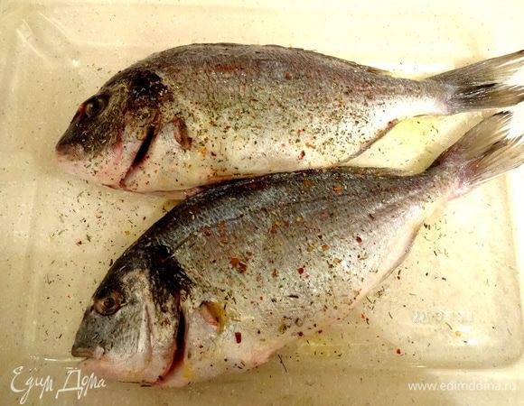 Очищенную от внутренностей, плавников и чешуи рыбку посолить, поперчить, приправить специями (у меня итальянские травы), сбрызнуть оливковым маслом, полить соком половины лимона. Мариновать 10 минут.