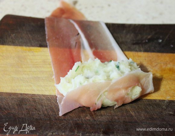 На край ломтика хамона, кладем столовую ложку пюре и аккуратно сворачиваем рулетиком.