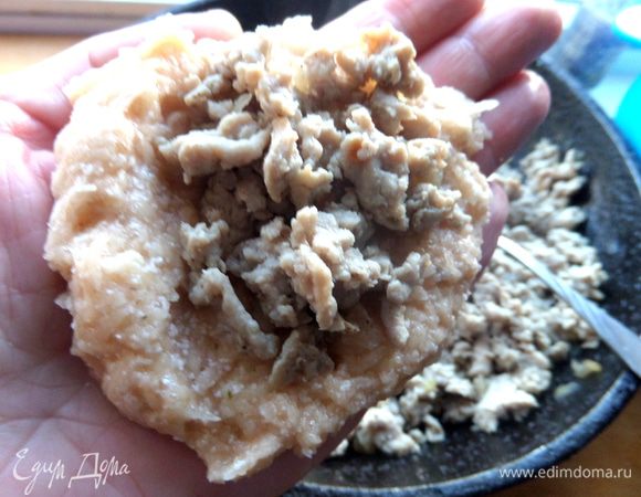 Смачиваем ладонь в воде (ставим рядом миску с водой), выкладываем на неё ложку картофеля, а сверху чайной ложкой фарш.