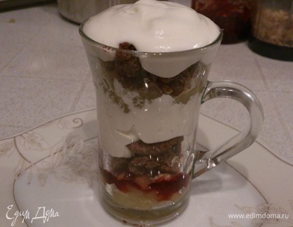Теперь приступаем к сборке пирога. На дно стакана выкладываем яблоки, сверху поливаем малиновым джемом. Посыпаем джем орехами и печеньем. Сверху печенья выкладываем сливки. Повторяем слои и украшаем яблочными чипсами. 