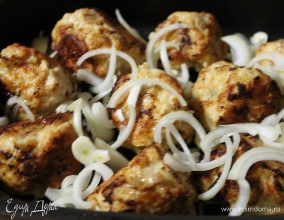 Обжаренные шарики сложить в форму для запекания, посыпать луком и чесноком.